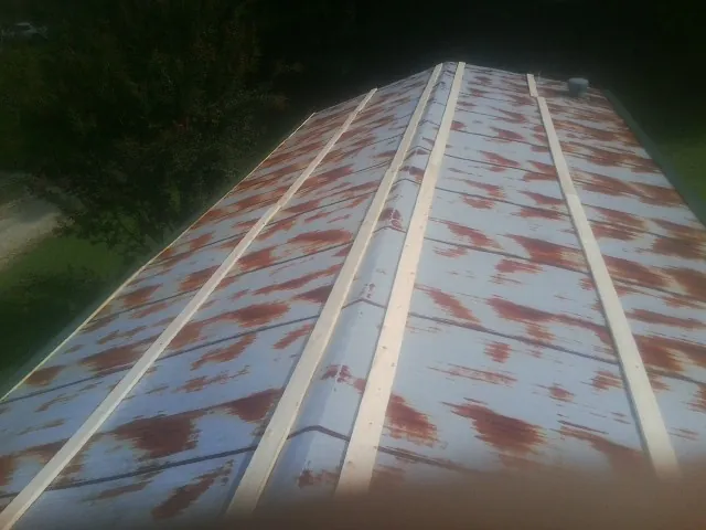 Rusted metal roof panels with new wood purlins before replacement — Storm Damage Roof Repair in Brick by Roofing Brothers
