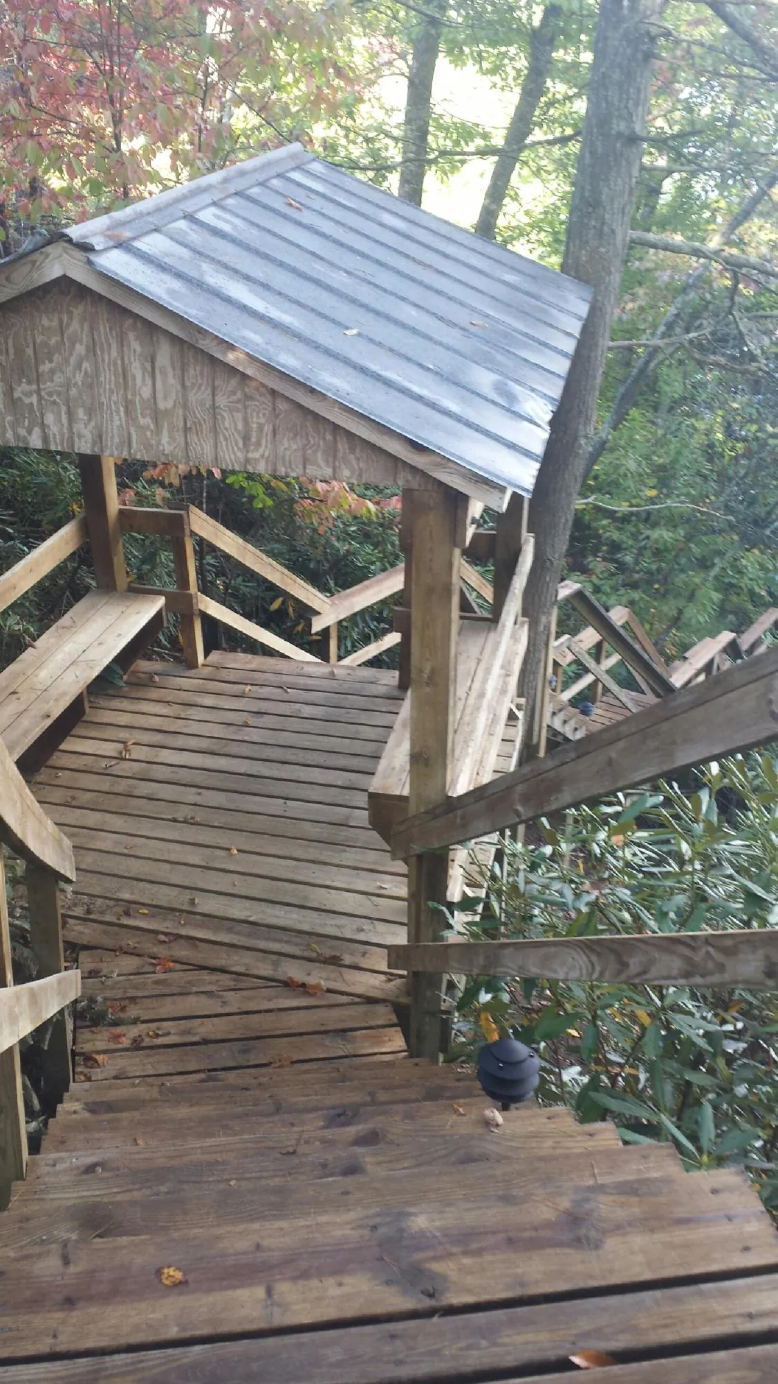 Metal roofed shelter over wooden steps on a wooded walkway — Skylight Repair & Installation work by our crew in Brick