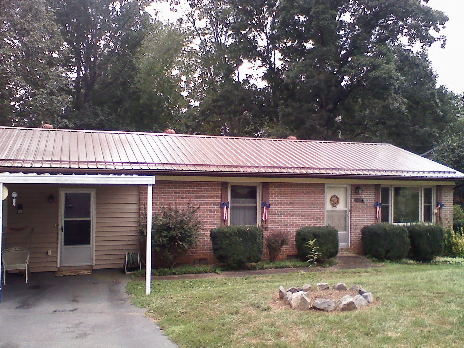 Bronze metal roof and carport on a brick ranch home — Roof Repair work by our crew in Brick